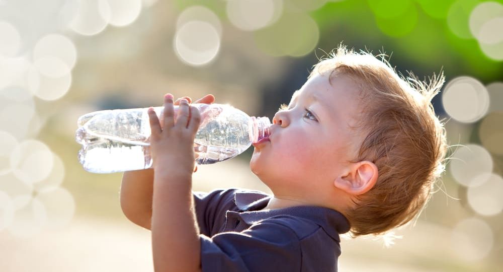 beautiful blonde child drink water outdoor