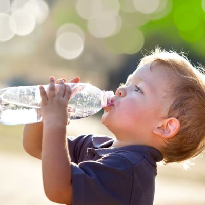 beautiful blonde child drink water outdoor