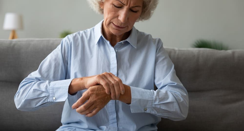 Unhappy older woman massaging wrist, feeling pain in joint