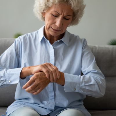 Unhappy older woman massaging wrist, feeling pain in joint